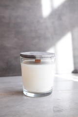 Organic scented soy candle on grey concrete cement table. Loft interior decor, minimalism concept.  Closeup, copy space for text