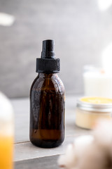 Spa cosmetics in brown glass bottles on gray concrete table. Copy space. Beauty blogger, salon therapy, minimalism concept