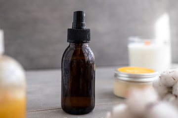 Spa cosmetics in brown glass bottles on gray concrete table. Copy space. Beauty blogger, salon therapy, minimalism concept