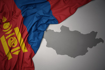waving colorful national flag and map of mongolia.