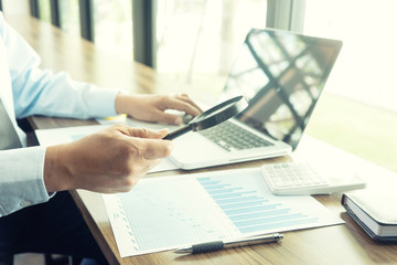 Businessman work with computer on table in office work with paper graph chart
