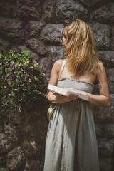 girl with a book near the wall