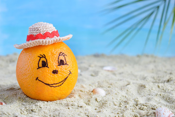 Fototapeta na wymiar Creative minimal summer idea. Orange citrus hipster in bamboo hat on sand. Tropical beach concept. Creative art. Fun party Mood. Copy space