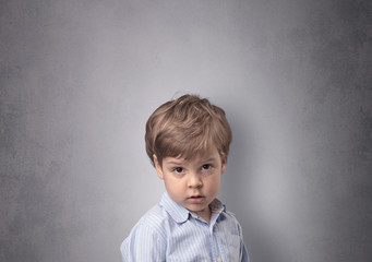 Fototapeta premium Adorable little boy portrait with empty grey wall background