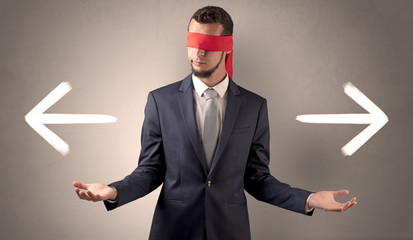 Covered eye businessman choosing between two directions 