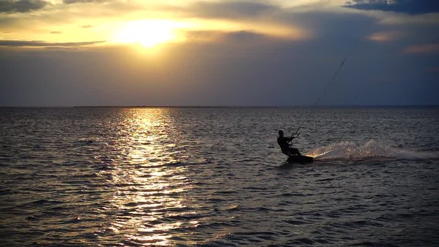 	Kite boarding. Slow motion.	Sunset over the sea.