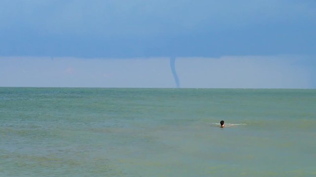	Tornado on the horizon in the sea.