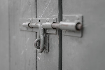 Close-up old bolt steel on green wooden doors