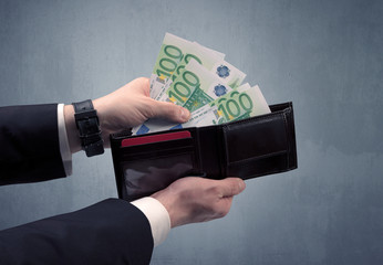Businessman's hand in suit takes out eruo from his wallet