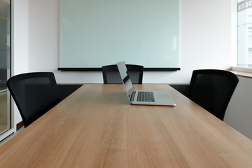 Laptop on table in empty corporate conference room