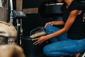 Female worker weigh unroasted coffee beans 