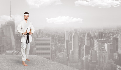 Young karate trainer doing karate tricks on the top of a metropolitan city
