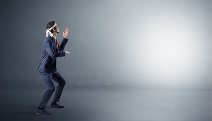 Businessman fighting with boxing gloves in an empty space
