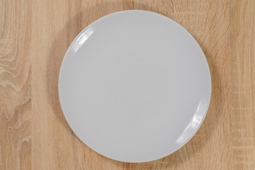 Weißer Teller aus Porzellan auf einem Holztisch 