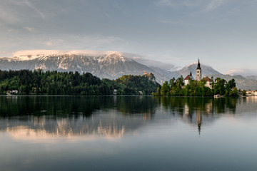 Fototapeta premium Amazing sunset time at famous Bled lake with church on the small island and a background of bled castle