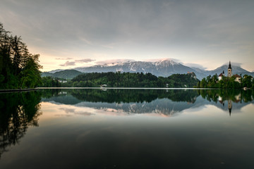 Amazing sunset time at famous Bled lake with church on the small island and a background of bled...
