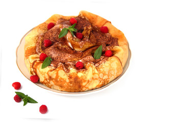 Round pancakes are placed in a heap. It is decorated in the form of a cake. The dish is decorated with whipped cream, fresh raspberries and a sprig of mint. Pancakes are the main dish of Maslenitsa.