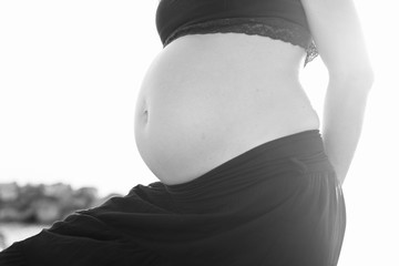 Pregnant woman, belly seen against the sun