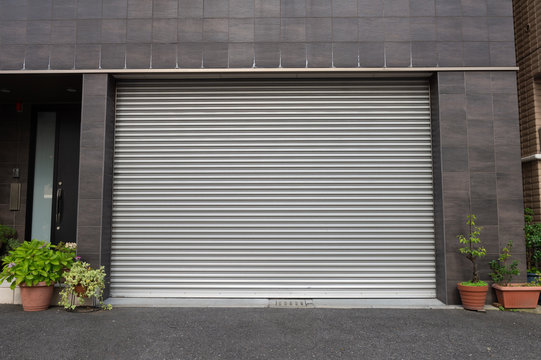 A Closeup Shot Of Automatic Metal Roller Door Used In Factory, Storage, Garage, And Industrial Warehouse. The Corrugated And Foldable Metal Sheet Offer Space Saving And Provide Urban And Rustic Feel