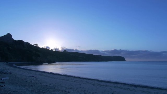 View across bay of Hokianga Harbour at sunset. Sun setting over Hokianga Heads far north of New Zealand.