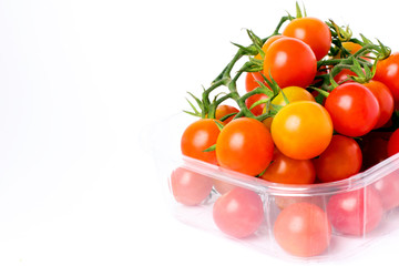 Cherry tomatoes on a branch in transparent retail plastic box
