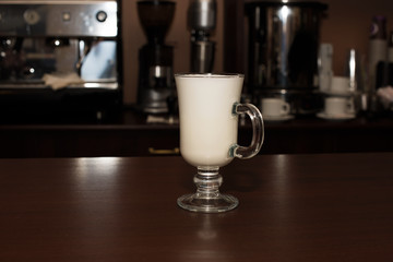 Boiled milk in a transparent glass on a cafe counter