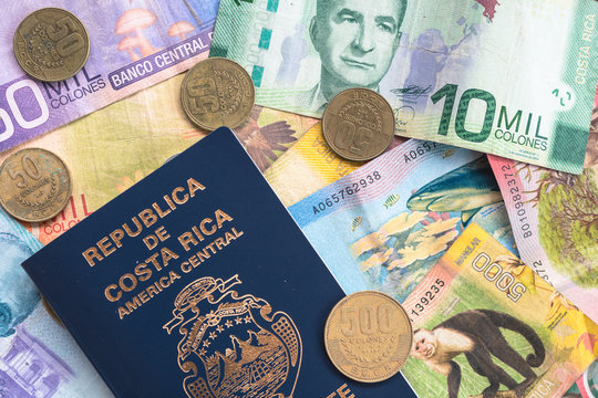 Flat lay of coin and paper currency from Costa Rica, with Costa Rican passport. 
