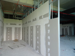 Drywall installation work in progress by construction workers at the construction site. It is the...