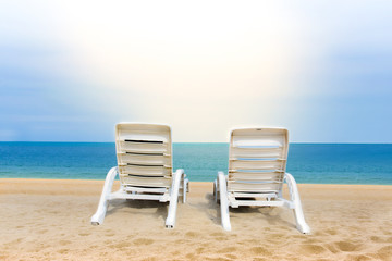 Sand beach with coconut trees with two chairs and bokeh beach tropical background, summer vacation and travel ideas, relaxation