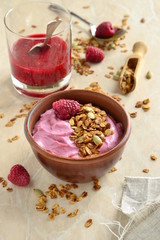 Raspberry smoothie with granola and pumpkin seeds, vertical
