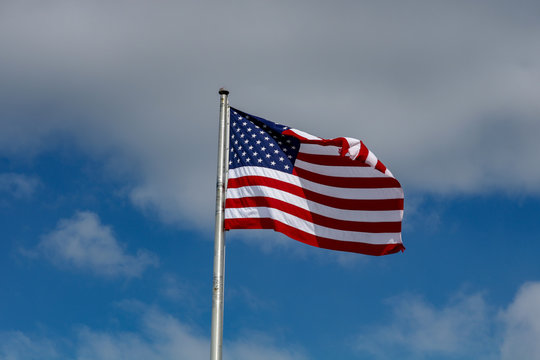 American Flag Against a Blue and Cloudy Sky