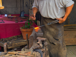 Schmied am Feuer bei der Arbeit