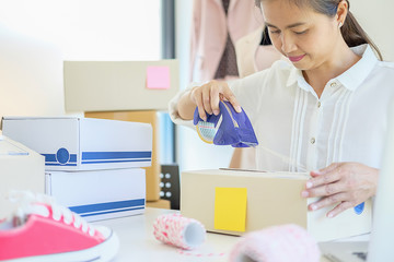 Cheerful charming young business owner standing in clothing shop