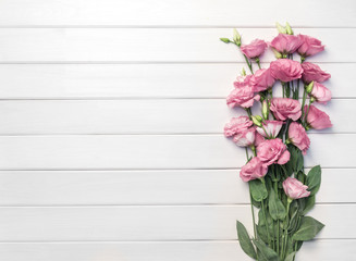 Beautiful pink eustoma flowers on white wooden background. Copy space, top view,