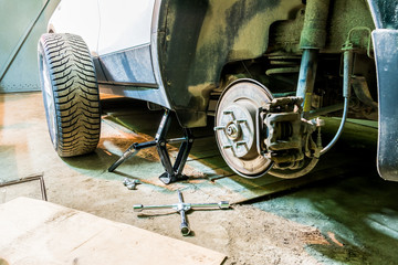 Mechanician changing car wheel in garage. Man exchanging tire. Tire service. Tire fitting.