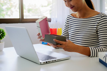 Young woman holding credit card and using laptop computer. Online shopping concept