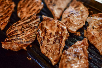 grilled chicken fillet, dark background, selective focus and copy space