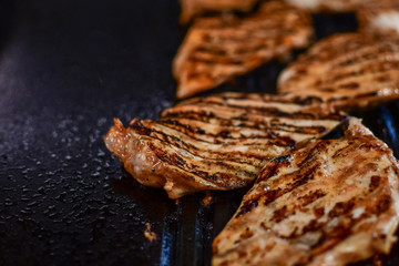 grilled chicken fillet, dark background, selective focus and copy space