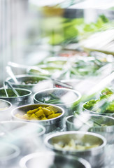 bowls of mixed fresh organic vegetables in salad bar display