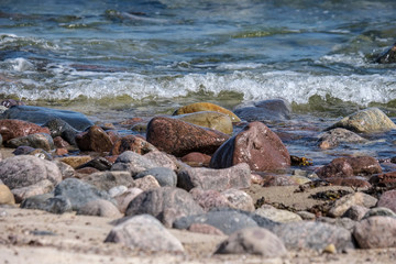 rocky sea beach with waves and sunny day