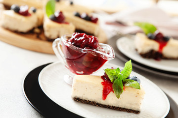 Classic New York cheesecake with fresh berries and cherry sauce on white plate