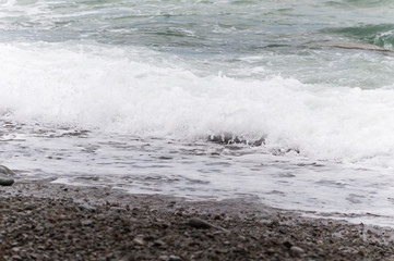Concrete pier on the shore of a pebbly beach