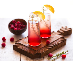 Summer refreshing non-alcoholic cocktails. Fruit drinks. Raspberry homemade lemonade with fresh organic rosemary and lemon. On a white wooden table.