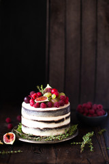 Obraz na płótnie Canvas Delicious chocolate cake with figs and berries on a rustic background. Wedding Naked cake with fruits in rustic style.