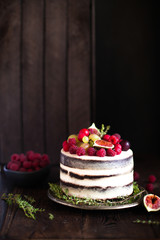 Delicious chocolate cake with figs and berries on a rustic background. Wedding Naked cake with fruits in rustic style.