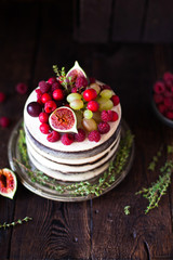 Delicious chocolate cake with figs and berries on a rustic background. Wedding Naked cake with fruits in rustic style.