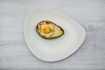 One egg baked in avocado on plate