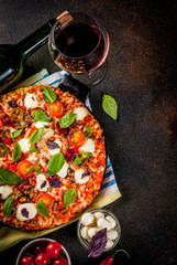 Pizza and red wine on dark background top view copy space