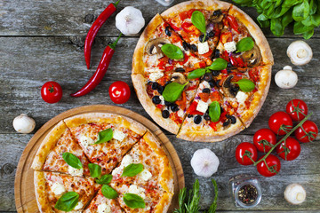 Homemade pizza with tomatoes, mozzarella and basil. Top view with copy space on wooden table. - 214381600