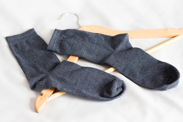 Black men's socks in the bedroom near the clothes hanger_